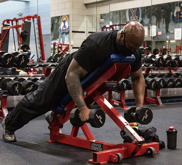 A man is lifting weights at a gym.