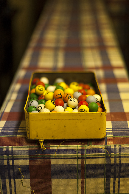 A box of numbered bingo balls is sitting on a table.