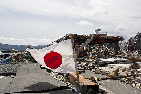 Foto de las secuelas del terremoto en Japón con un enfoque en la bandera japonesa.