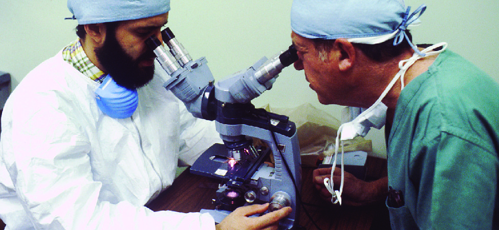 两位科学家操作显微镜的照片。