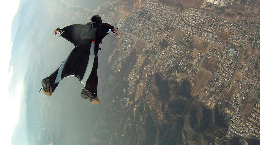 Uma pessoa caindo em uma roupa de asa, que funciona para reduzir a velocidade vertical da queda de um paraquedista.