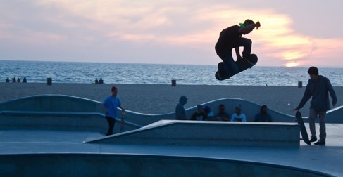 Skateboarders at a skating rink by the beach.