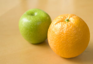 Apple sitting next to an Orange
