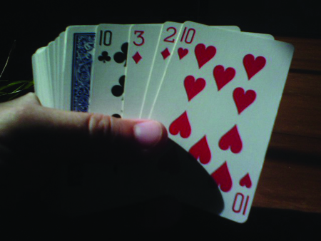 La figura muestra a alguien sosteniendo una baraja de cartas.