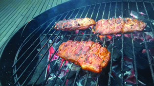 Una fotografía de carne cocinada en una parrilla de carbón.
