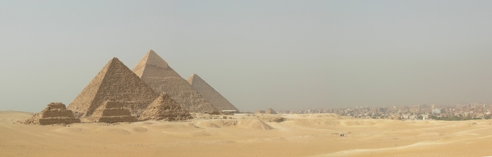 Foto de las pirámides egipcias cerca de una ciudad moderna.
