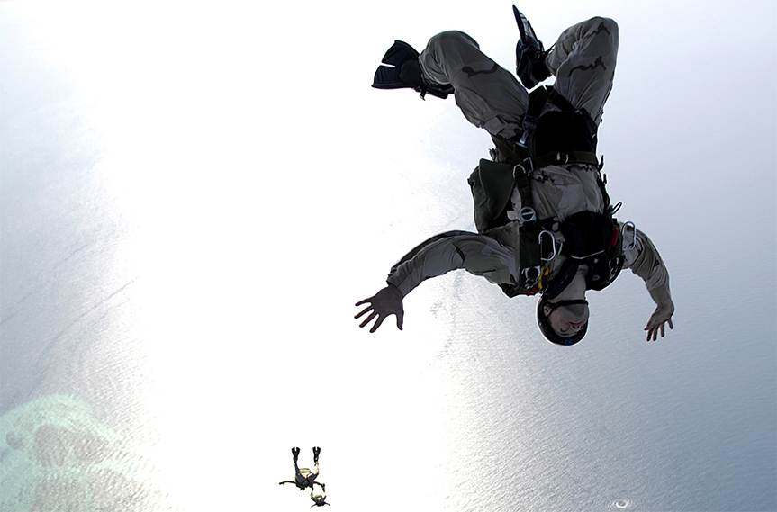 Deux parachutistes tombent librement dans le ciel.