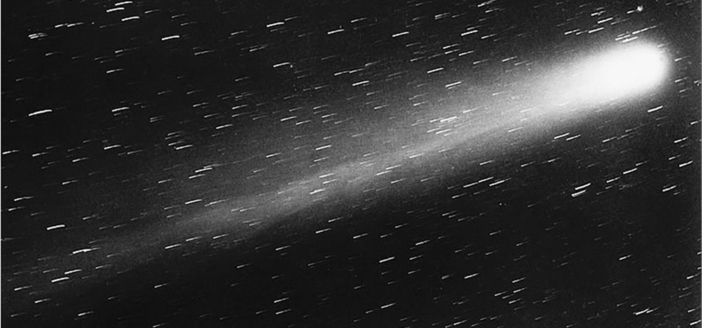 Esta es una foto del cometa Halley. Se trata de una brillante bola de luz hacia la derecha de la imagen con una cola de luz posterior. También hay estrellas a lo largo de la imagen.